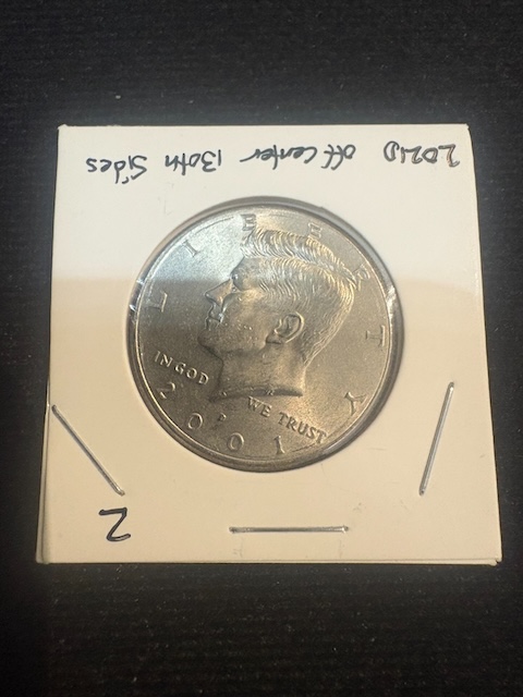 2001 Kennedy half dollar off-center strike error with design shifted approximately 20-30% off center showing blank planchet area